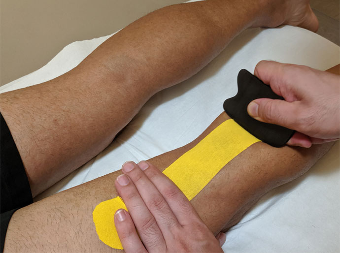 masaje deportivo en Badajoz haciendo neurotaping en una pierna